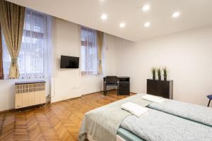 a bedroom with two beds and a desk and a television at Cozy 3 bedrooms in 7st districht in Budapest