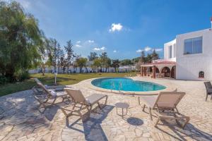 a patio with chairs and a swimming pool at villa des jasmins in Tunis