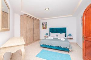 a bedroom with a large bed with a blue blanket at villa des jasmins in Tunis