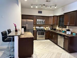 a large kitchen with wooden cabinets and stainless steel appliances at Hidden Gem Cozy Home MiCasa TuCasa in El Paso