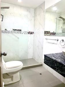a bathroom with a toilet and a shower and a sink at Hotel Yivinaca in Barranquilla