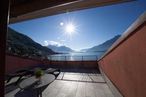 a balcony with a table and a view of a lake at Nuovo Bar Centrale in Gravedona
