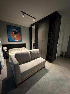 1 dormitorio con 1 cama y 1 sofá en Estúdio com garagem no Bairro do Jardins, en São Paulo