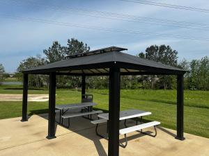a gazebo with a picnic table and benches at Super 8 by Wyndham Spring/North Houston in Spring