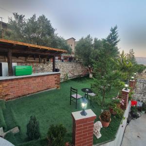 a backyard with a lawn and a brick wall at Villa Mehmeti in Sarandë