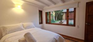 a bedroom with a white bed and a window at CASONA DE LOS VIRREYES in Villa de Leyva