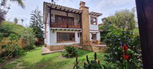 a house with a balcony on top of a yard at CASONA DE LOS VIRREYES in Villa de Leyva