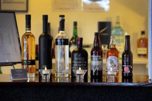 a group of bottles of wine and glasses on a bar at Ty Helyg Guest House in Brecon