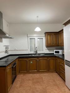 an empty kitchen with wooden cabinets and a sink at LA CALDERETA CASA RURAL in La Oliva