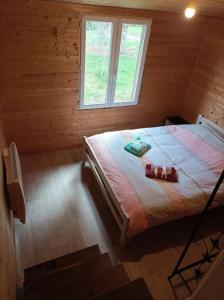 a bedroom with a bed in a wooden cabin at Chez Julien et Mélanie in La Frugerie
