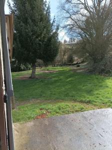 an open door to a yard with a tree at Chez Julien et Mélanie in La Frugerie