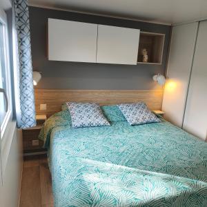 a bedroom with a bed with a blue comforter at Le Colorful in Dinard