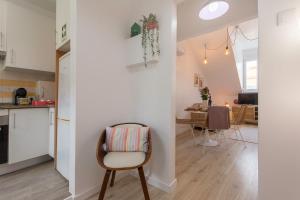 リスボンにあるNew Bright and Cozy Apartment in Graçaのキッチン、リビングルーム(椅子、テーブル付)