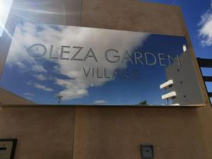 um sinal num edifício que lê Glenza Garden Village em Oleza Garden Village , Apartment Ines em Playa Flamenca