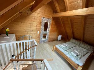 een kamer met een bed in een houten hut bij Sky Apartments in Rust