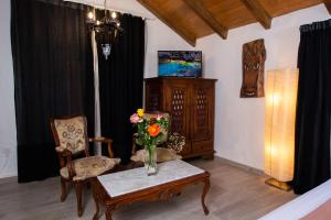 a living room with a vase of flowers on a table at Geko Hotels in Los Llanillos