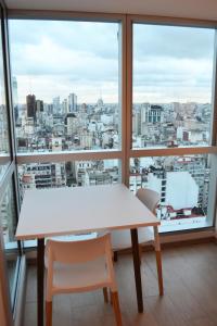 mesa y sillas en una habitación con ventana grande en Blue Dream Esmeralda en Buenos Aires