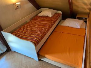 a couple of beds in a small room at Chaleureux chalet en bord de mer in Merville-Franceville-Plage