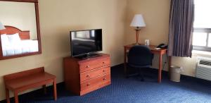 Habitación de hotel con TV, escritorio y cama en Motel 6 East Windsor, NJ Hightstown, en East Windsor