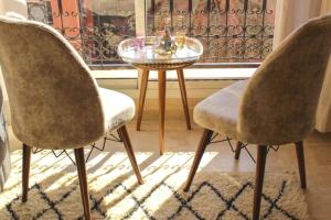 twee stoelen en een tafel voor een raam bij Bright Apt in the Heart of Marrakech-Walk Everywhere in Marrakesh