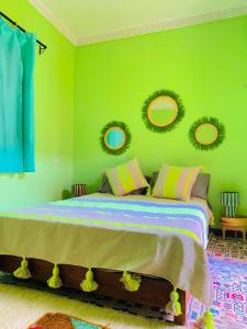 a bedroom with a bed with green walls and mirrors at RIAD GALIYA in Marrakech