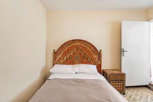 a bedroom with a bed with a wooden headboard at Hamriya villa in Meknès