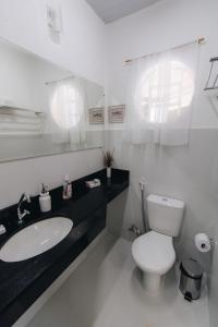 a white bathroom with a toilet and a sink at Hotel Fazenda Bona Espero in Alto Paraíso de Goiás