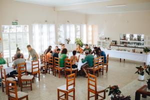 un grupo de personas sentadas en mesas en una habitación en Hotel Fazenda Bona Espero, en Alto Paraíso de Goiás