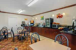 a dining room with tables and chairs and a kitchen at Quality Inn Riverview Enola-Harrisburg in Harrisburg