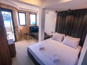 ein Schlafzimmer mit einem großen weißen Bett und einem Sofa in der Unterkunft Sand Apartments in Ulcinj