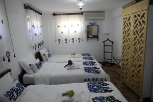Adahan Bozcaada Otel في بوزجادا: سريرين في غرفة ذات لون أبيض وأزرق