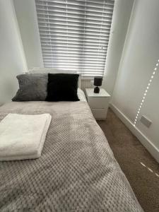 Un dormitorio con una cama grande y una ventana en Seaforth Deluxe 2 bedroom apartment at Rockman Luxury Short Stays Lets and Accommodation, en Southend-on-Sea