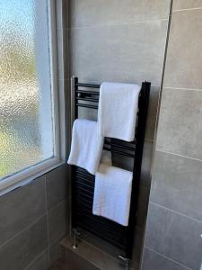- Baño con toallero eléctrico y toallas blancas en Seaforth Deluxe 2 bedroom apartment at Rockman Luxury Short Stays Lets and Accommodation, en Southend-on-Sea