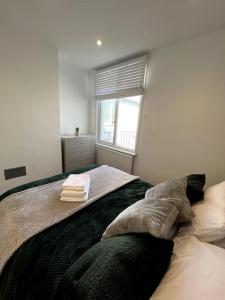 1 dormitorio con cama con almohadas y ventana en Seaforth Deluxe 2 bedroom apartment at Rockman Luxury Short Stays Lets and Accommodation, en Southend-on-Sea