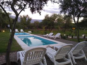 a group of white chairs around a swimming pool at La Comarca Loft in San Javier