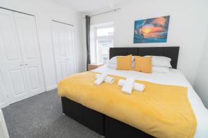 a bedroom with a large bed with two towels on it at Business friendly 3BR home - King size beds & Centrally located in Swansea