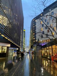 people walking down a wet city street with buildings at Sanctuary Spaces at The Shard with private parking in London