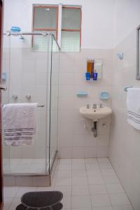 baño blanco con ducha y lavamanos en Casa Hudié Campestre, en Cachipay