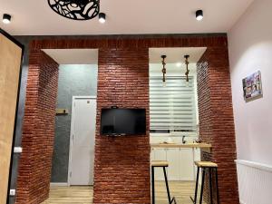 a brick wall in a kitchen with a tv on a wall at Room 42 in Tbilisi City