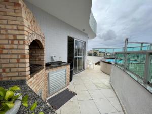 - un balcon d'une maison avec un four extérieur dans l'établissement Cobertura com piscina em Cabo Frio, à Cabo Frio