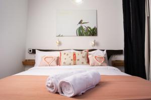 1 dormitorio con 1 cama con 2 toallas en Geko Hotels, en Los Llanillos