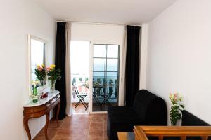 un soggiorno con divano e vista su un balcone di Geko Hotels a Los Llanillos