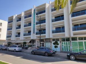 a building with cars parked in front of it at Hôtel Résidence Louban in Agadir