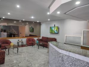 - un hall avec un bar avec des chaises et une télévision dans l'établissement Hôtel Résidence Louban, à Agadir