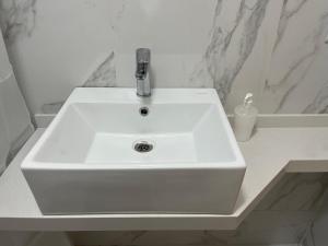 ein weißes Waschbecken mit einem Wasserhahn in einem Badezimmer in der Unterkunft Monoambiente Urquiza in Buenos Aires + 9 Fotos