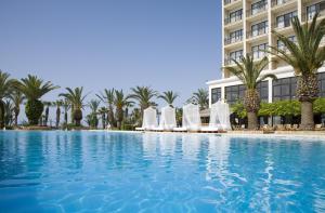 a swimming pool in front of a hotel at Sandy Beach Hotel & Spa - ex Sentido in Larnaca