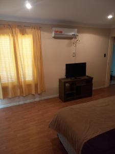 a bedroom with a bed and a flat screen tv at Departamento Residencial in San Fernando del Valle de Catamarca