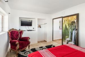 a bedroom with a bed and a chair and a tv at Gîte Nature in Azrou