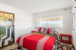 a bedroom with a red bed and a window at Gîte Nature in Azrou