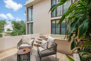 a patio with two chairs and a table at 205 Perfect Location 3 bedrooms Apartment in Tulum